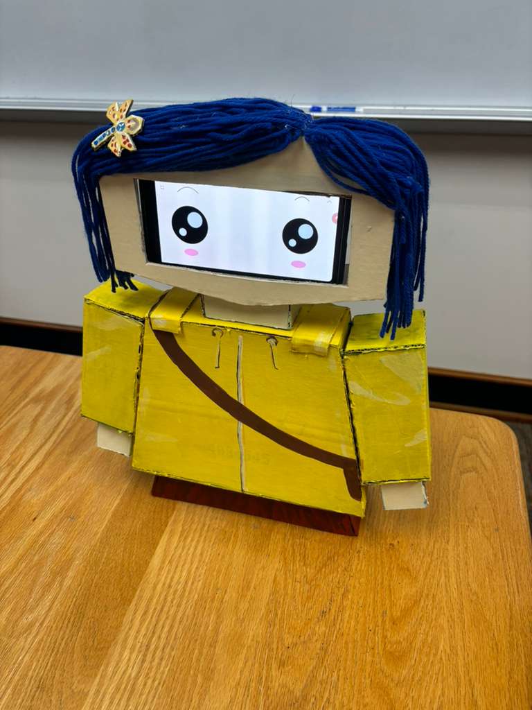 Coraline costume social robot made from cardboard and yellow rainjacket with button eyes.